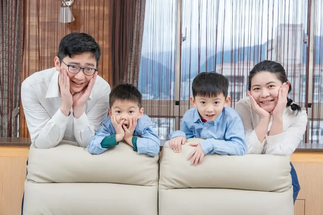 溫馨居家風全家福 - 一家四口在沙發上托腮裝可愛的趣味合影